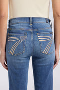 Blue jeans with decorative stitching on a plain background