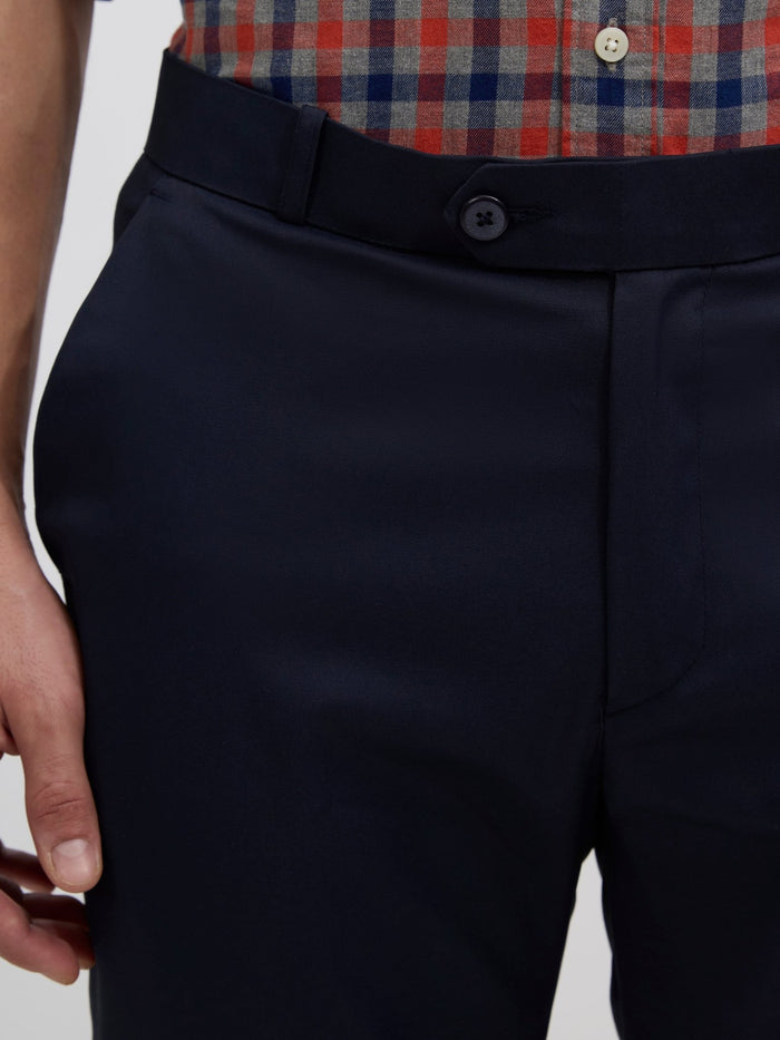men's navy blue skinny fit trousers blended with polyster and spandex - paired with a black top and black shoes.