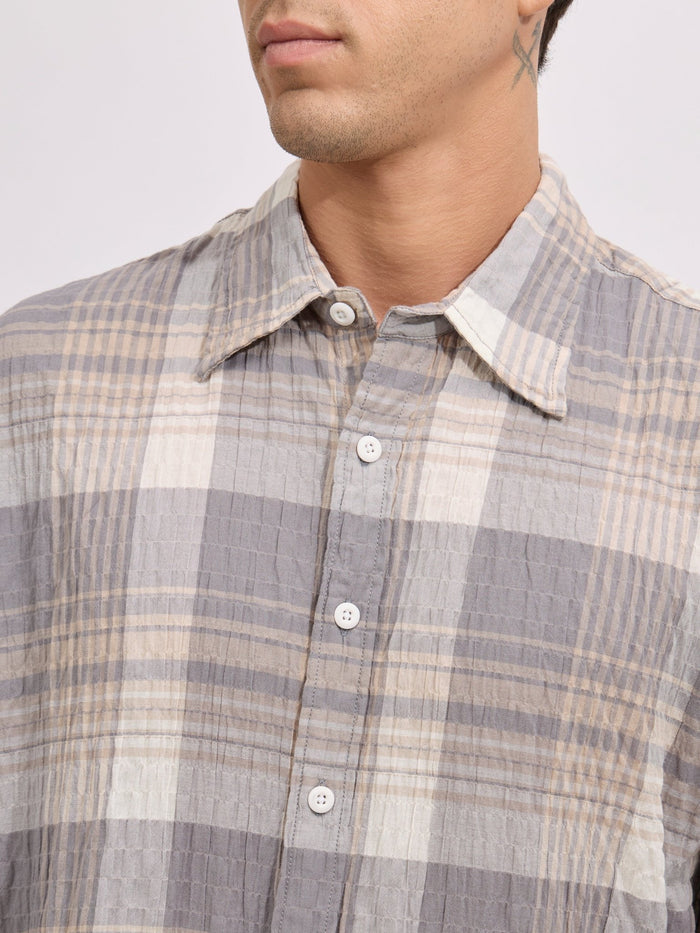 Men's oversized grey checkered cotton shirt with full sleeves, styled with beige trousers – casual fashion look