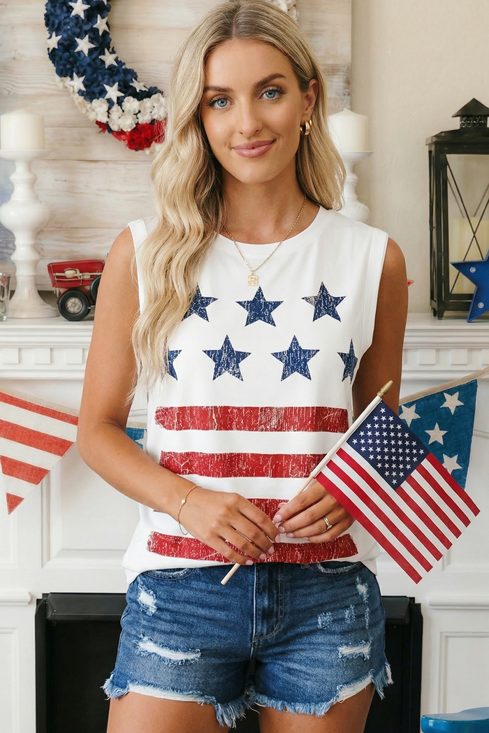 Woman wearing a sleeveless top with American flag design, holding small American flags, in a decorated room.