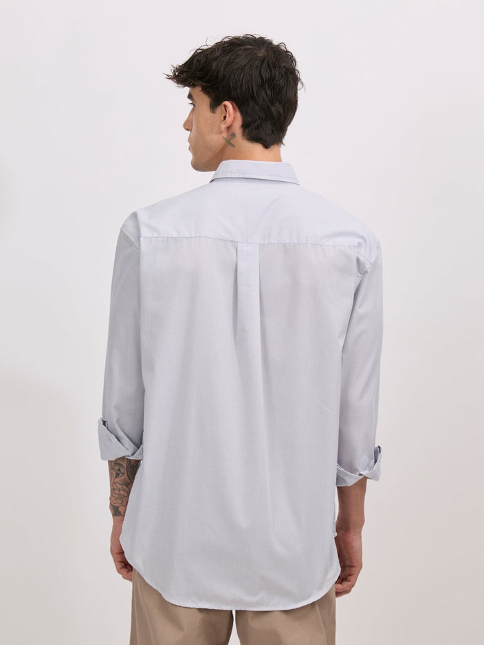 Man wearing grey cotton oversized striped shirt with rolled sleeves, front pocket, and button-down collar
100% cotton