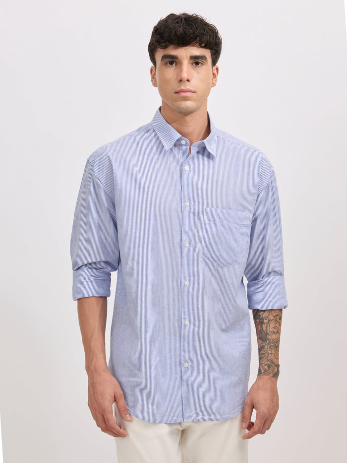 Man wearing sky blue cotton oversized striped shirt with rolled sleeves, front pocket, and button-down collar
100% cotton