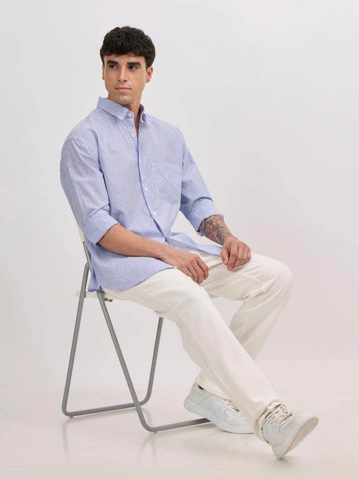 Man wearing sky blue cotton oversized striped shirt with rolled sleeves, front pocket, and button-down collar
100% cotton