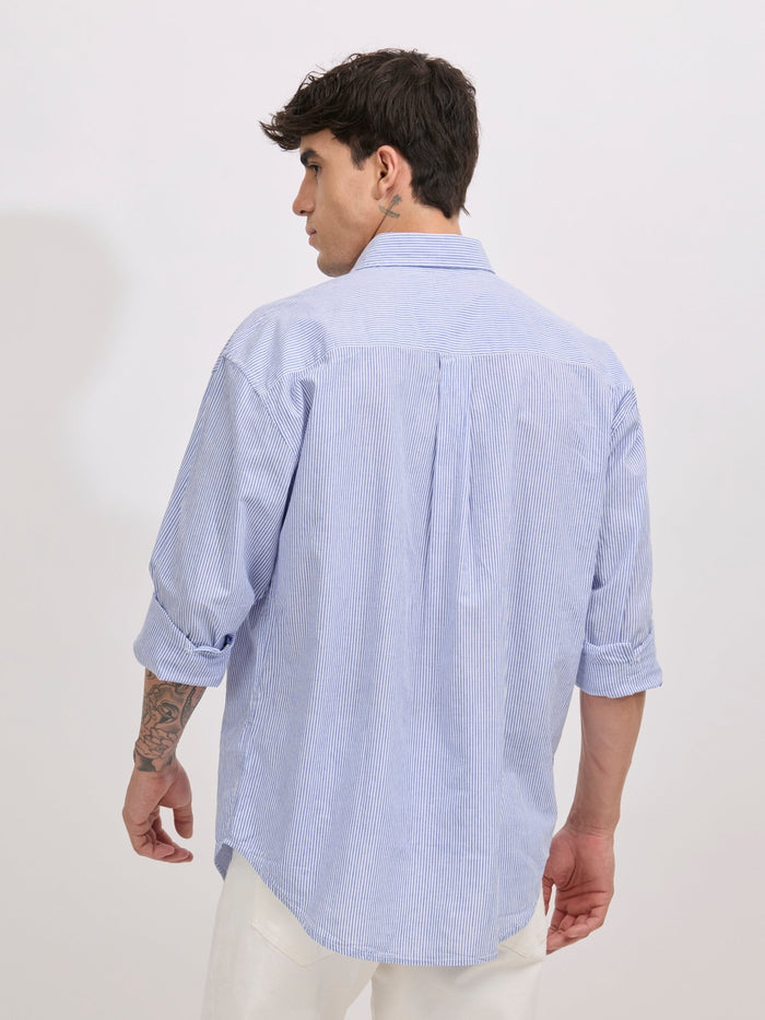 Man wearing sky blue cotton oversized striped shirt with rolled sleeves, front pocket, and button-down collar
100% cotton